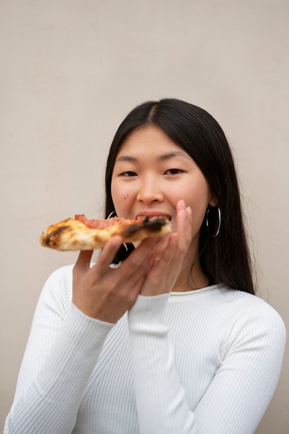 Foto gratuita donna di vista frontale che mangia pizza deliziosa