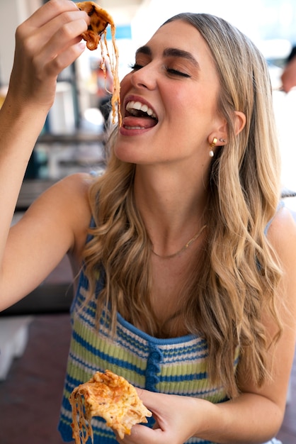 Foto gratuita donna di vista frontale che mangia in un modo divertente