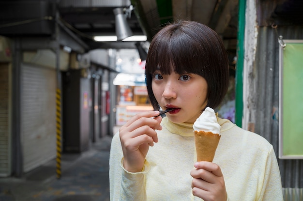 アイスクリームを食べる正面図の女性