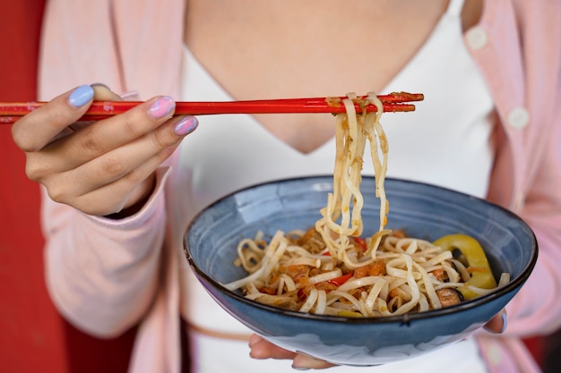 Free photo front view woman eating noodles