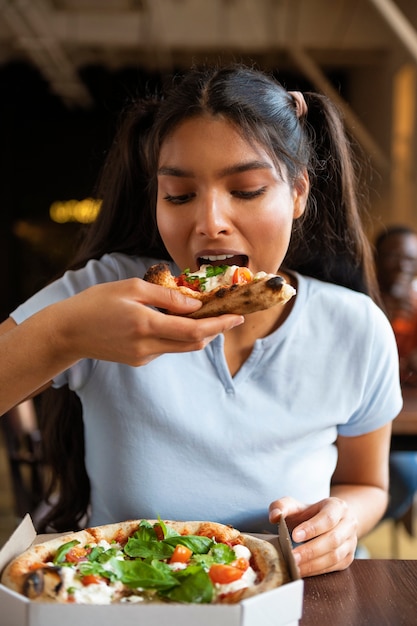 Front view woman eating pizza