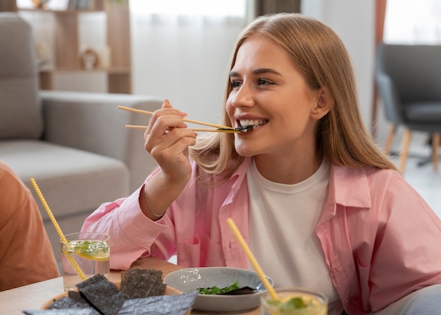 Foto gratuita donna di vista frontale che mangia spuntini alle alghe