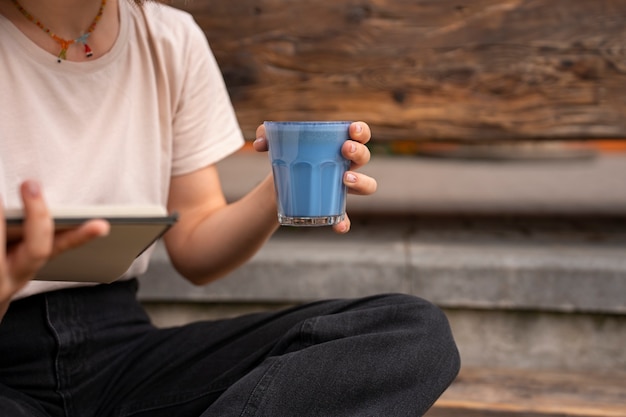 Free photo front view woman enjoying a blue matcha