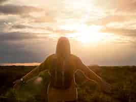 Foto gratuita donna di vista frontale che gode del tramonto