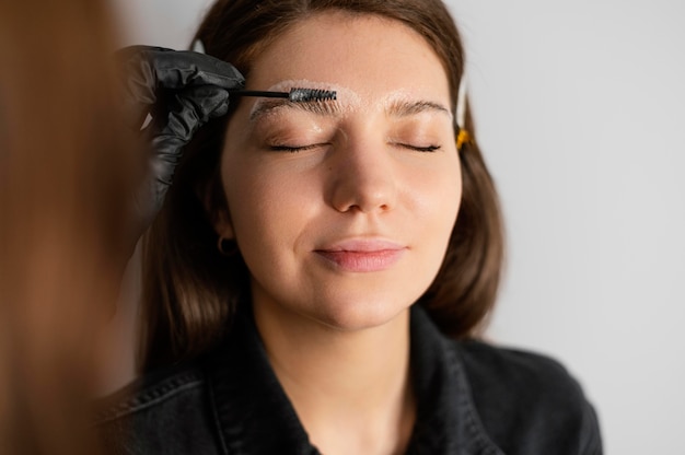 Free photo front view of woman getting an eyebrow treatment