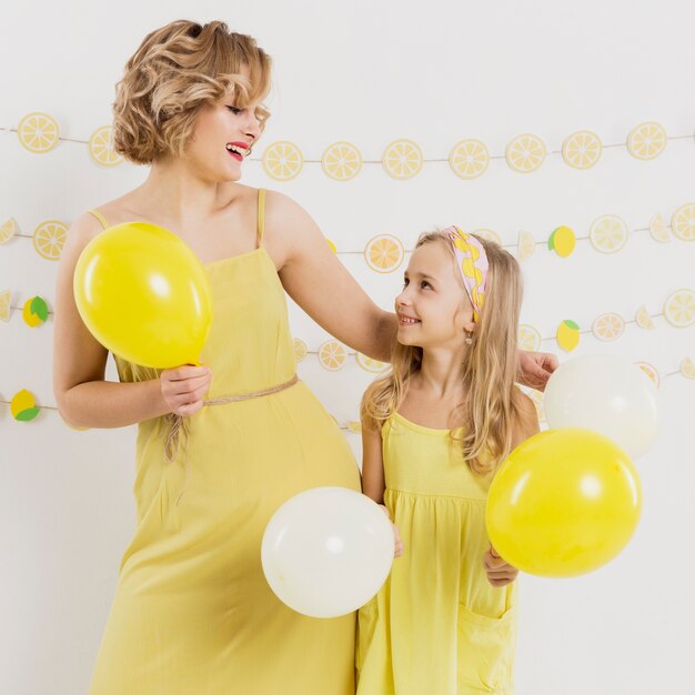 Front view of woman and girl posing with balloons