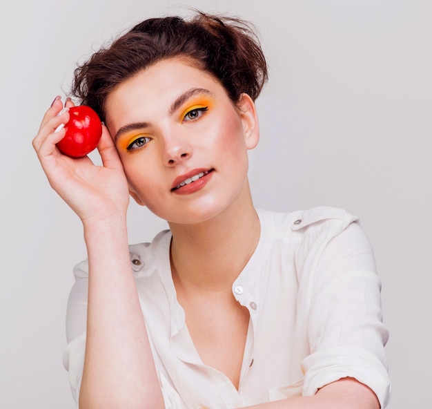 Front view of woman holding an apple