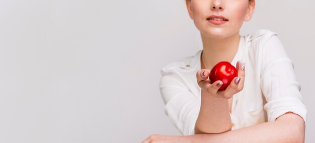 Front view of woman holding an apple