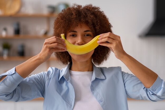 バナナを保持している正面図の女性