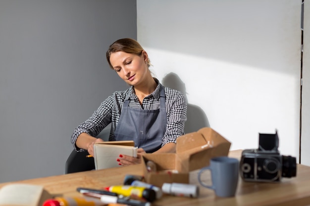 Free photo front view of woman holding book at desk