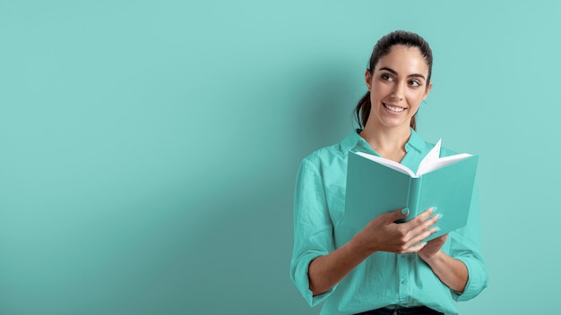 Free photo front view of woman holding book with copy space