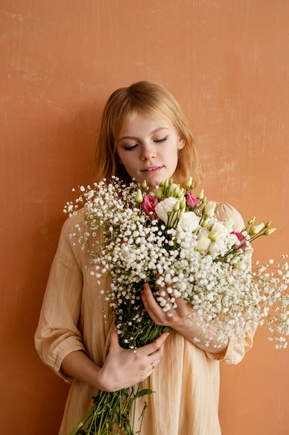 美しい春の花の花束を保持している女性の正面図