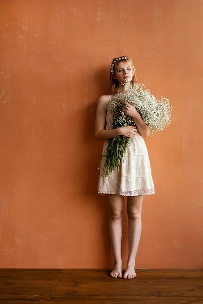 Free photo front view of woman holding bouquet of flowers with copy space