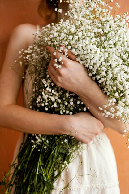 Вид спереди женщины, держащей букет цветов