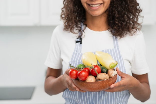 Foto gratuita donna di vista frontale che tiene una ciotola con le verdure