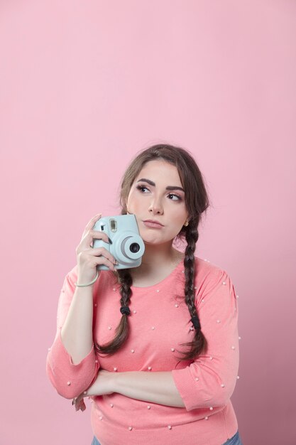 Front view of woman holding camera with copy space