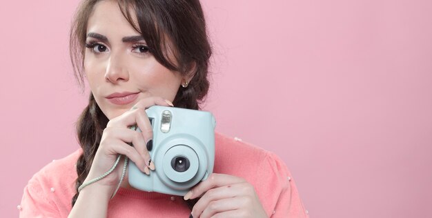 Front view of woman holding camera with copy space