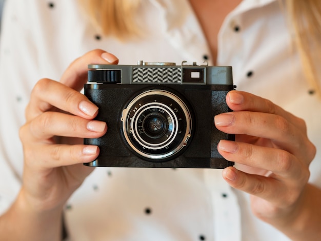 Foto gratuita macchina fotografica della tenuta della donna di vista frontale