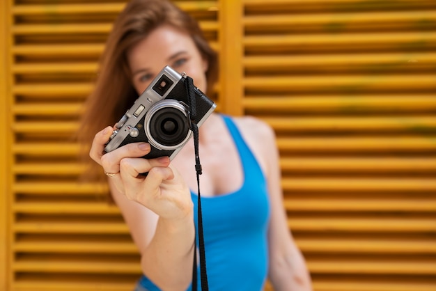 Foto gratuita macchina fotografica della tenuta della donna di vista frontale