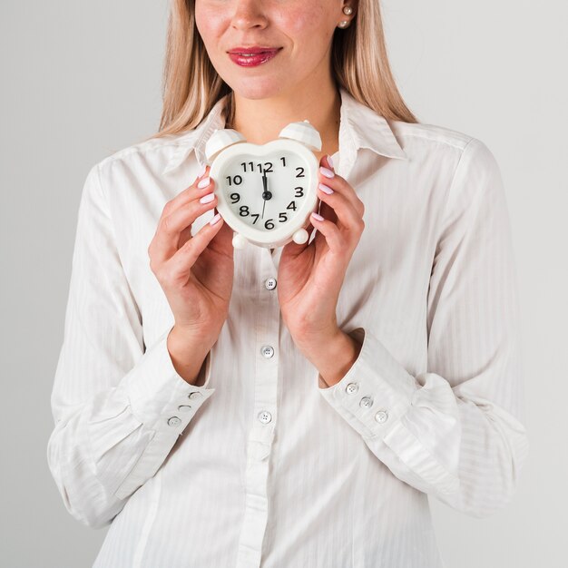 Front view of woman holding clock