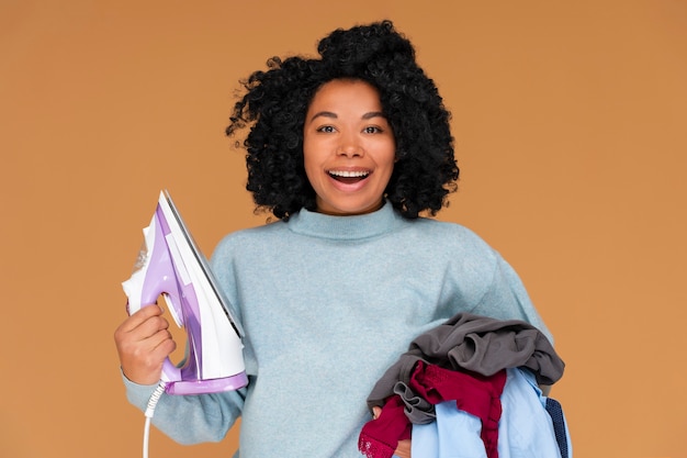 Free photo front view woman holding clothes and iron