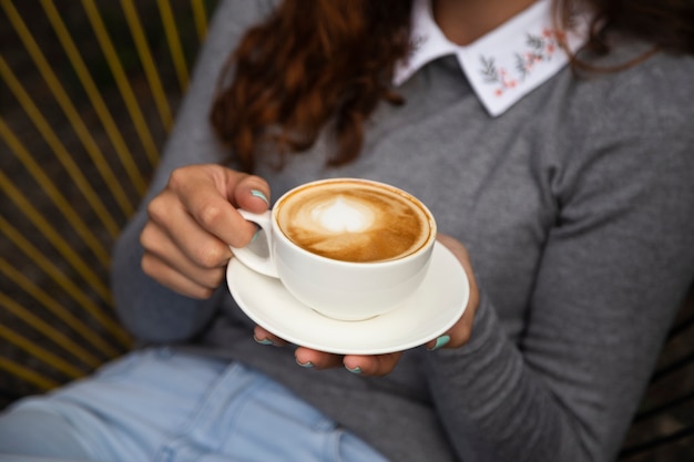 Foto gratuita vista frontale della tazza di caffè della holding della donna