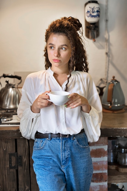 Бесплатное фото Женщина вид спереди держит чашку кофе