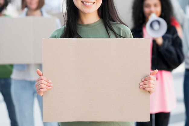 Front view woman holding copy space cardboard