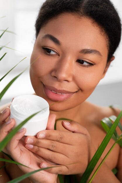 Front view woman holding cream container