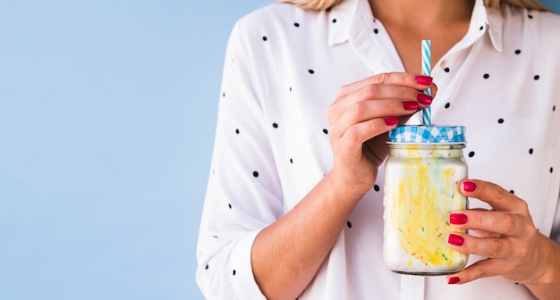 Free photo front view of a woman holding delicious milkshake with copy space