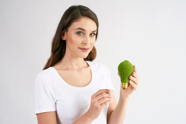 Front view of woman holding a energy efficient light bulb