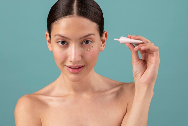 Front view woman holding eye product