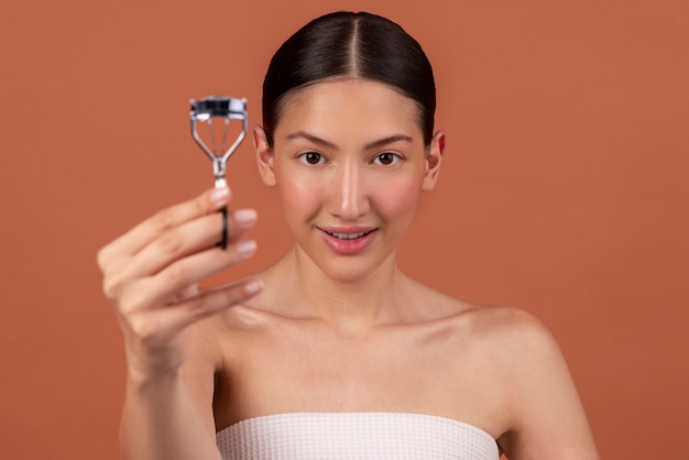 Front view woman holding eyelash curler