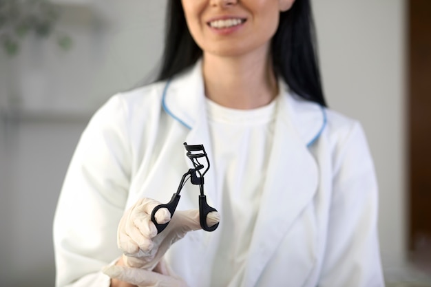 Front view woman holding eyelash curler