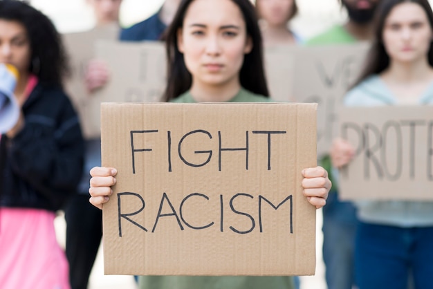 Front view woman holding fight racism quote