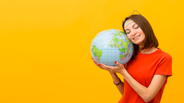 Front view of woman holding globe with copy space