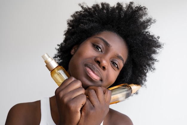 Foto gratuita prodotti per capelli della holding della donna di vista frontale