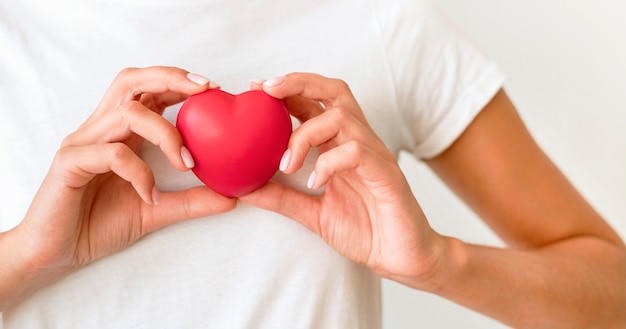 Free photo front view of woman holding heart shape