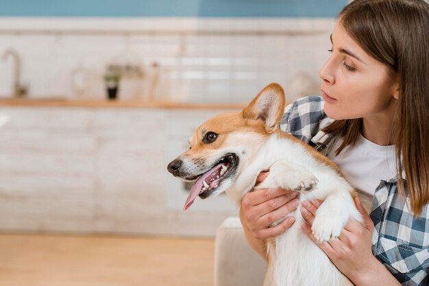 彼女の愛らしい犬を保持している女性の正面図