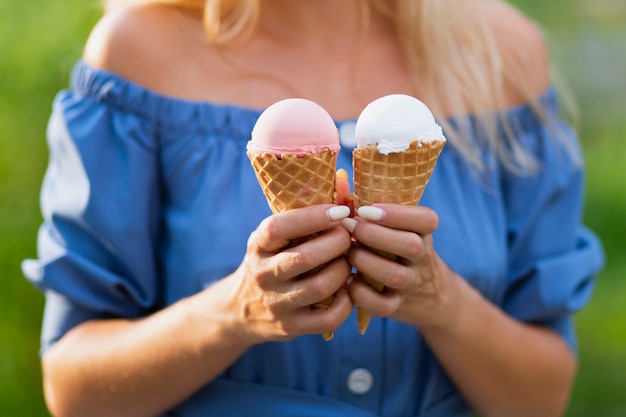 Front view of woman holding ice cream cones