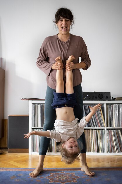 Front view woman holding kid upside down