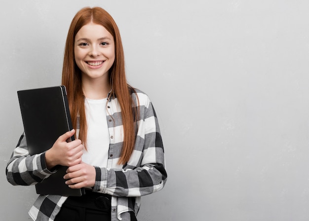 Foto gratuita computer portatile della tenuta della donna di vista frontale