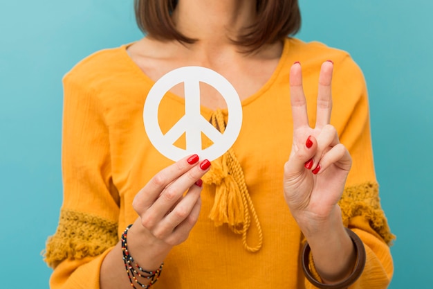 Front view woman holding and making peace sign