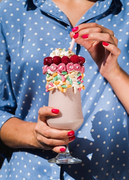 Front view of a woman holding a milkshake