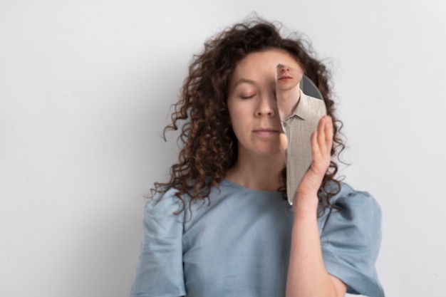 Front view woman holding mirror piece