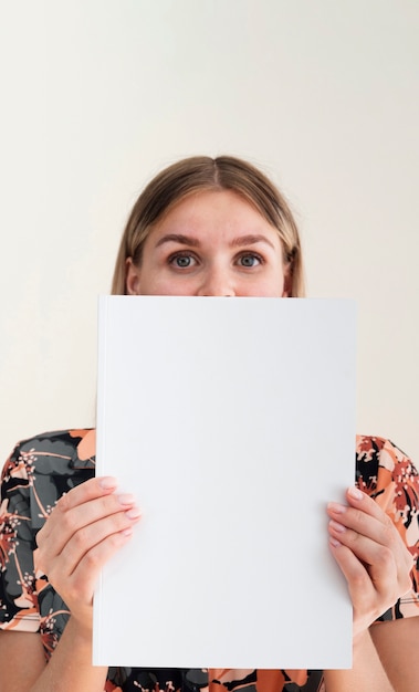 Front view woman holding a mock-up magazine