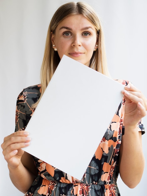 Front view woman holding a mock-up magazine