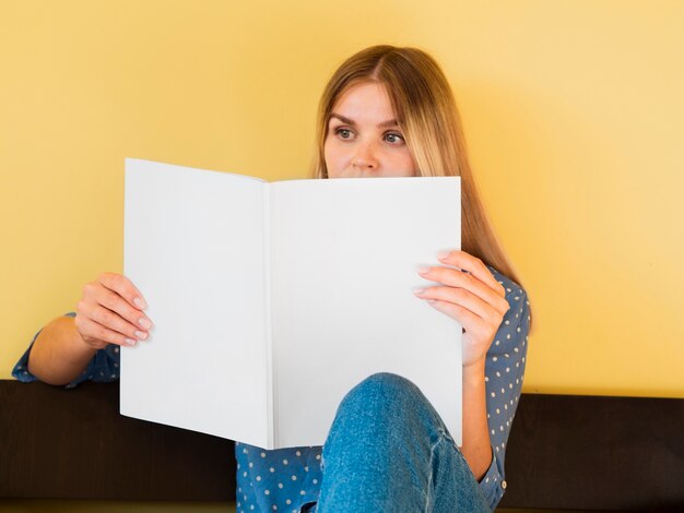 Front view woman holding a mock-up magazine