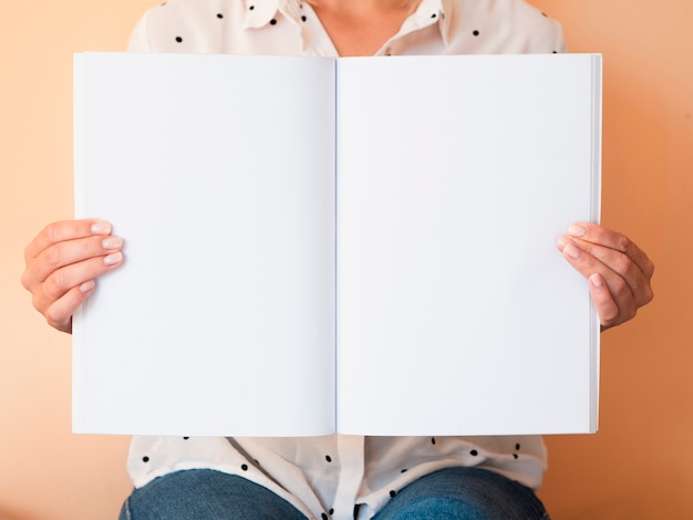 Front view woman holding a mock-up magazine