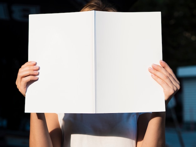 Front view woman holding a mock-up magazine